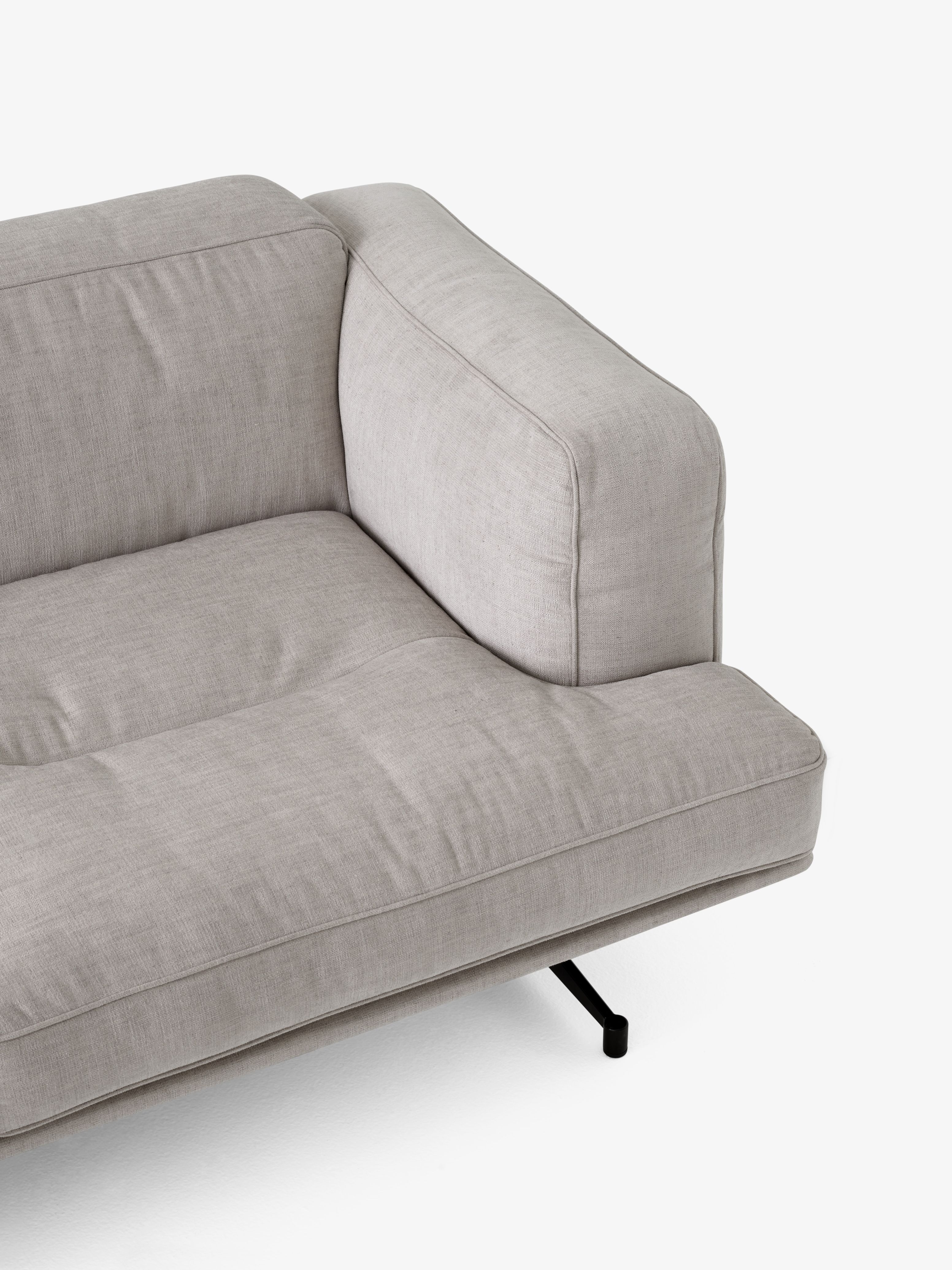 Detailaufnahme des AndTradition Inland Sofas AV22/AV23 in hellem Stoffbezug mit Armlehne und schwarzem Metallfuß.