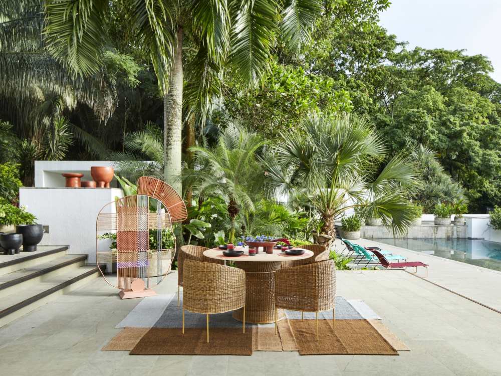 Ames Caribe Esstisch Outdoor aus Naturmaterialien mit Stühlen in tropischer Umgebung.