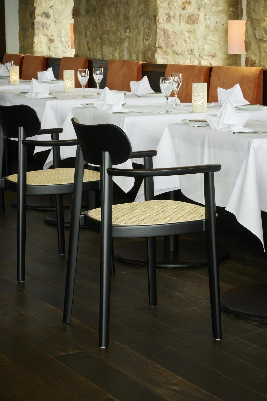 Schwarzer 118 FV Holzstuhl mit Armlehnen von Thonet, Wiener Geflecht Sitzfläche, im Restaurant Ambiente.