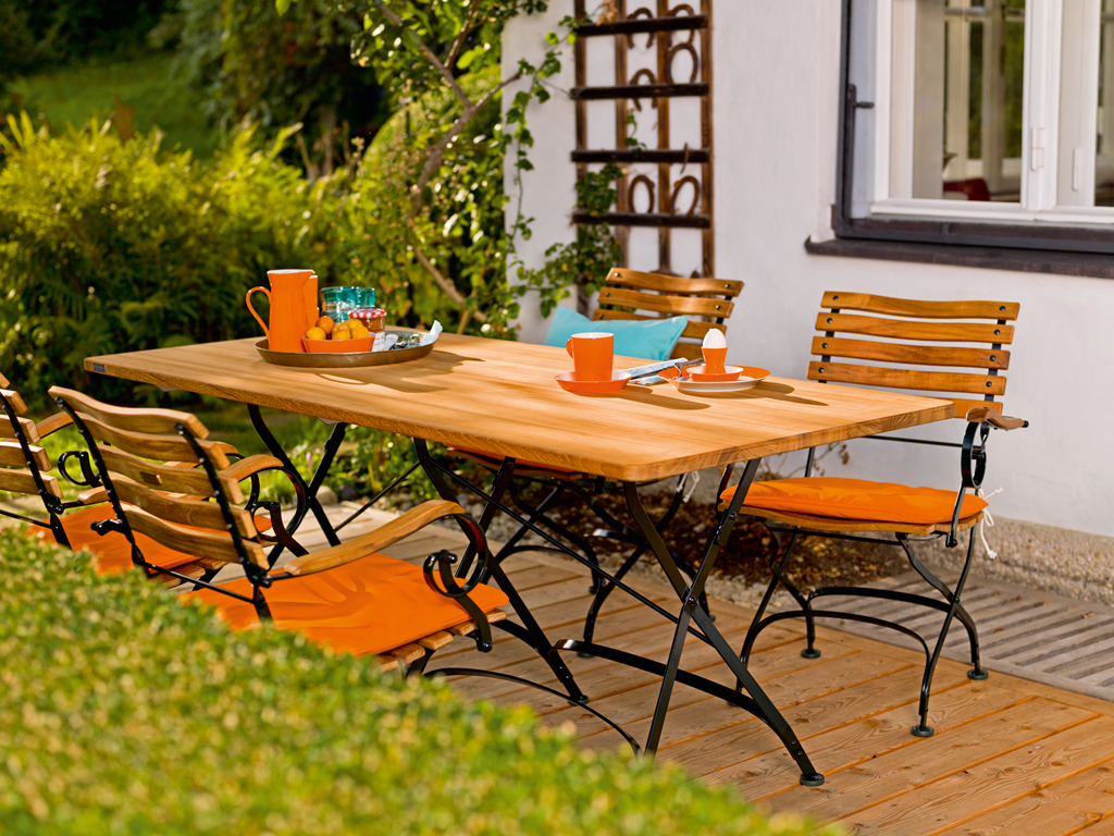 Weishäupl Classic Armchair Sessel mit Armlehnen und Holztisch auf einer Terrasse im Garten.