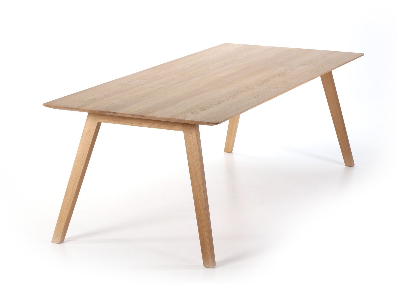Monk Tisch von Prostoria, Esstisch aus hellem Holz mit schrägen Beinen auf weißem Hintergrund.