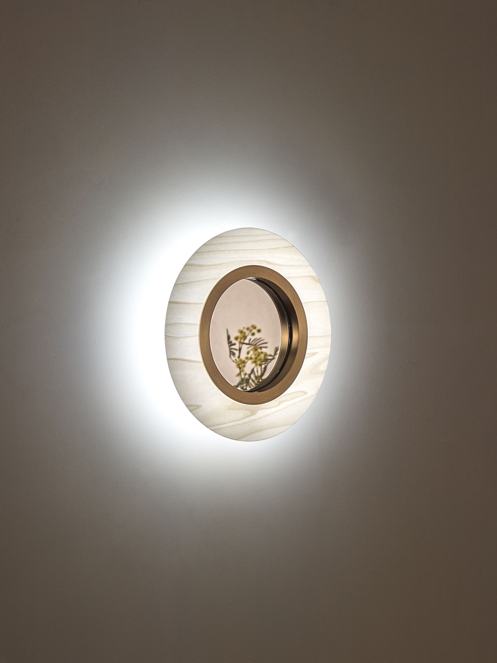 Lens LED Wandleuchte von LZF Lamps: Runde Wandlampe mit goldenem Metallring und indirektem Licht.