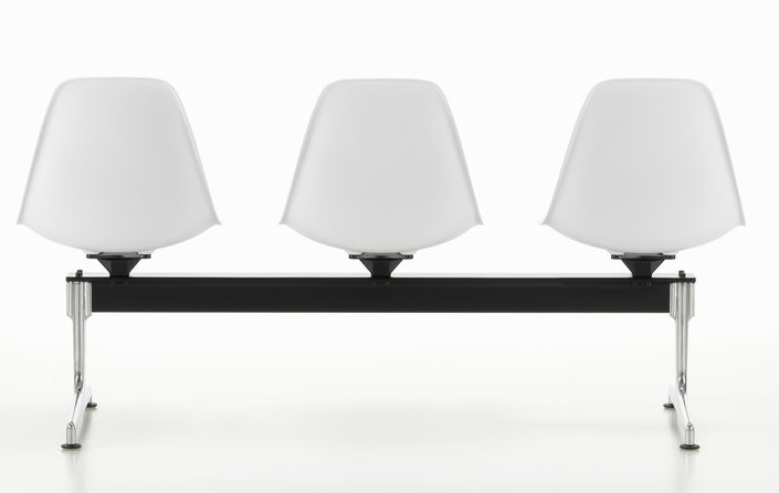 Eames Side Chair RE auf Traverse Vitra, Wartebank mit drei weißen Kunststoffschalen und schwarzem Untergestell.