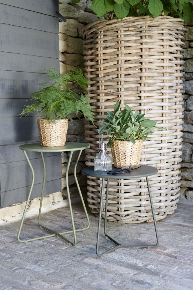 Zwei Cocotte Hocker von Fermob im Garten, einer mit Pflanze, Outdoor-Möbel.