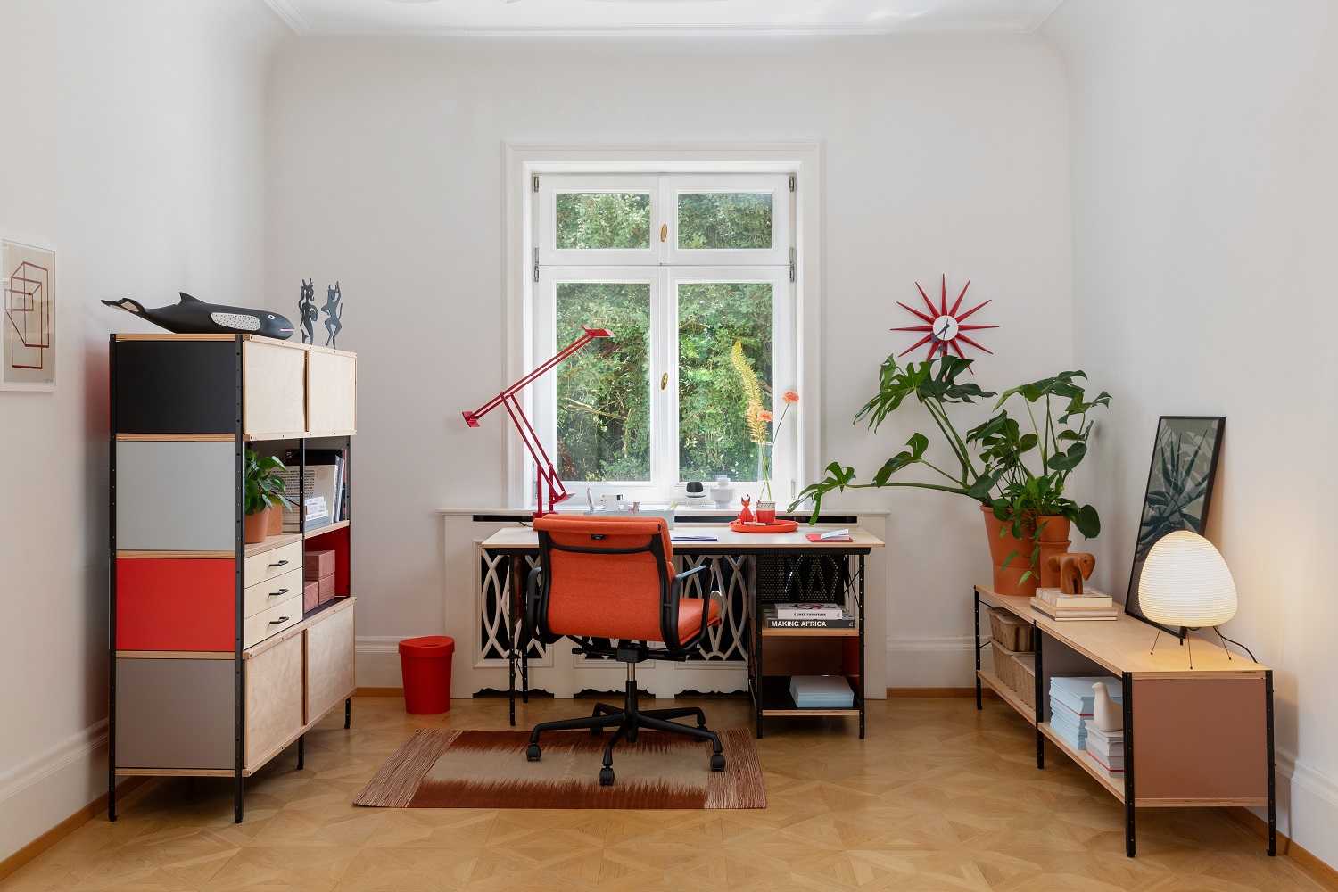 Büro mit Vitra EA 217 Soft Pad Chair in Orange, Schreibtisch, Regalen und Dekoration.