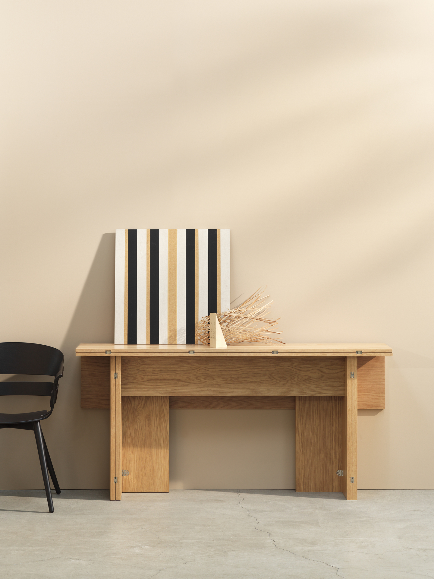 Design House Stockholm Flip Table Klapptisch aus Eichenholz mit Deko und schwarzem Stuhl.