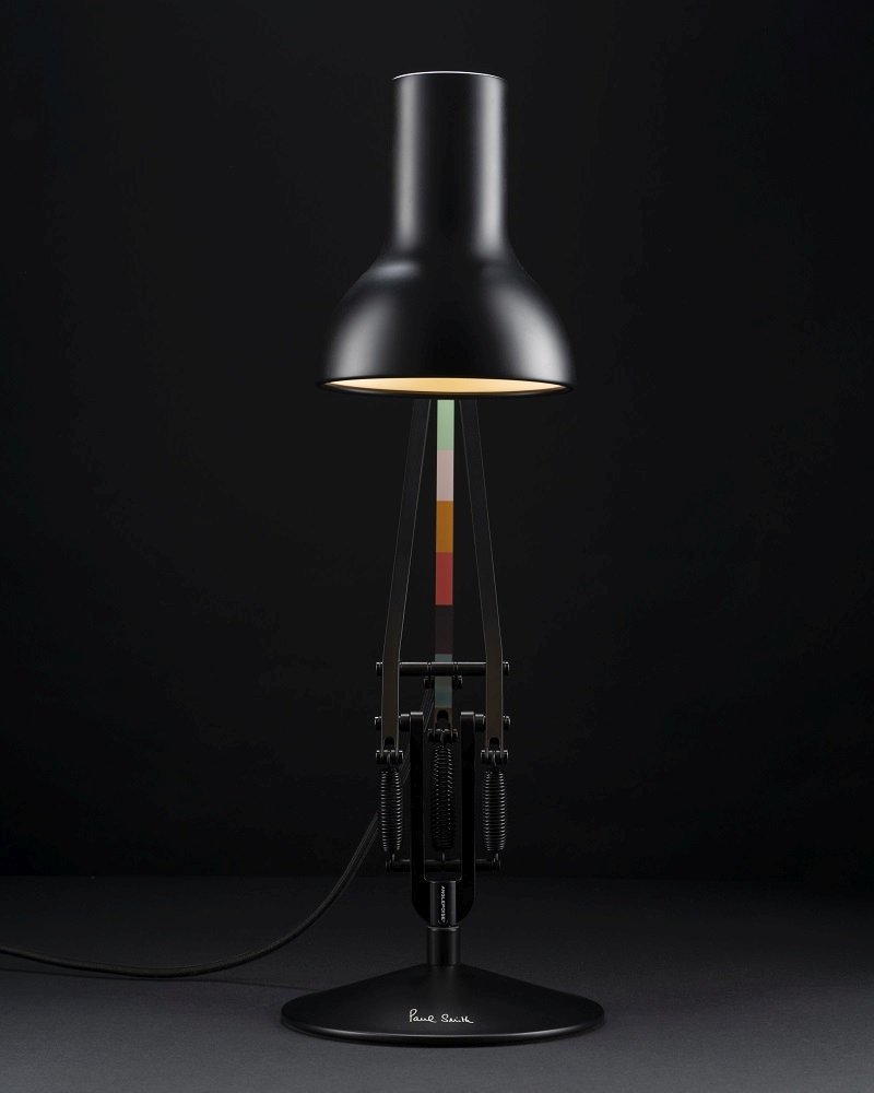 Schwarze Anglepoise Type 75 Mini Paul Smith Edition Tischleuchte mit farbigen Akzenten vor dunklem Hintergrund.