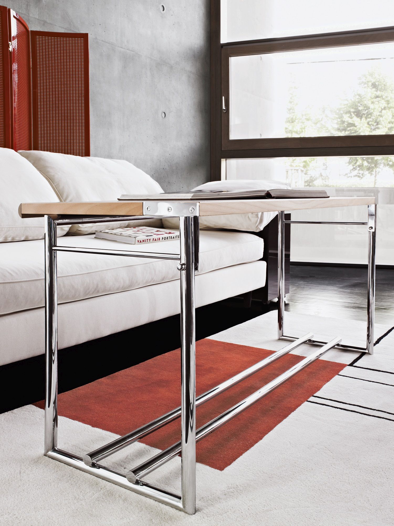Nahaufnahme des Classicon Lota Sofas mit minimalistischem Beistelltisch und modernem Teppich im Wohnzimmer.