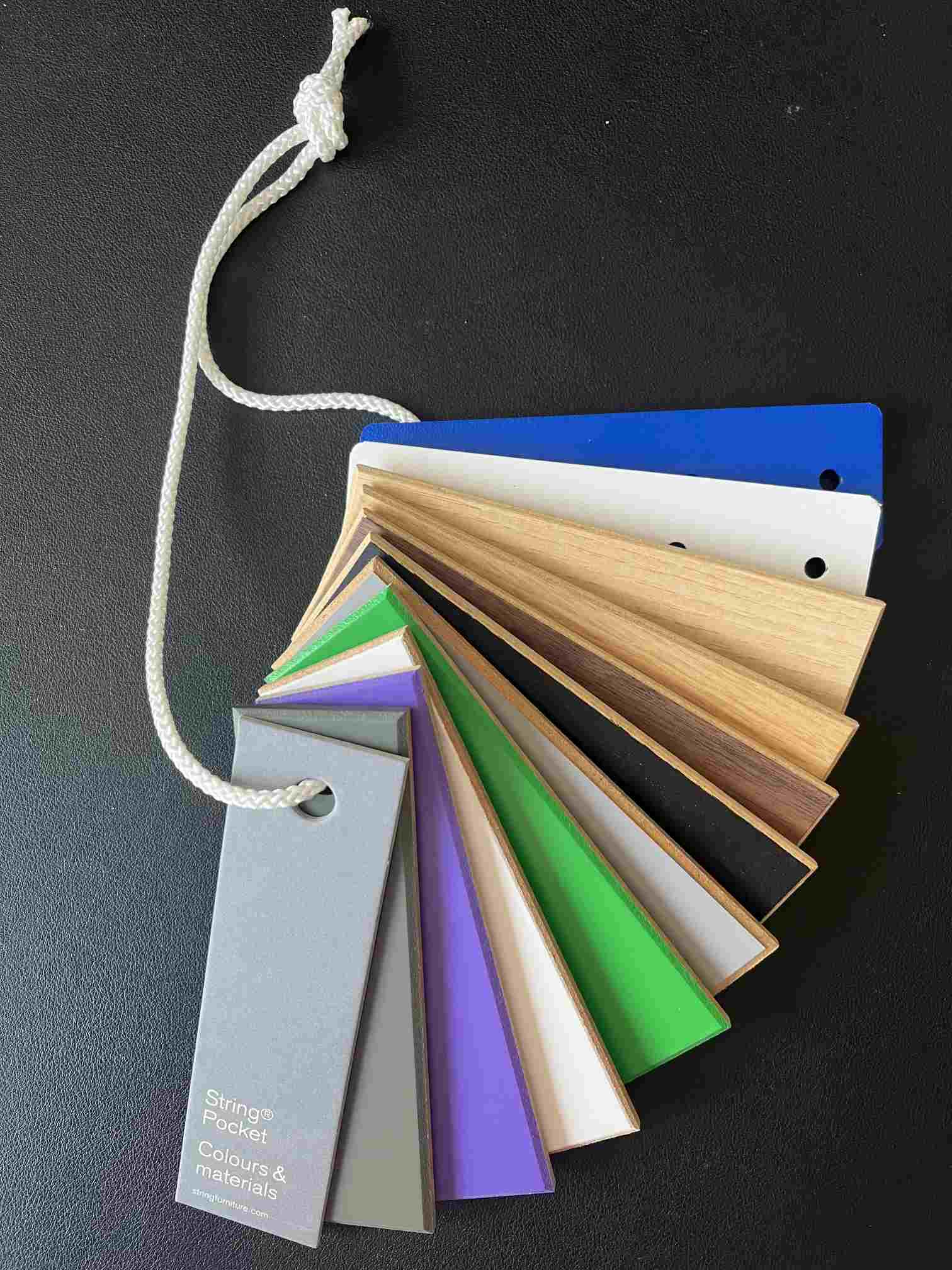 Mustersatz für String Pocket Regal: Farb- und Materialauswahl für String Regalsysteme, aufgefächert mit Kordel.