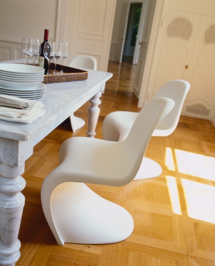 Weißer Panton Chair Kunststoffstuhl von Vitra im Esszimmer mit Marmortisch und Parkettboden.