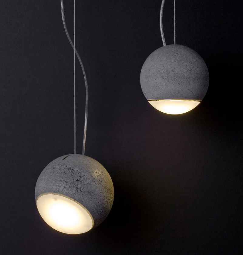 Zwei moderne graue Beton-Hängeleuchten in Kugelform mit warmweißem Licht vor dunklem Hintergrund.