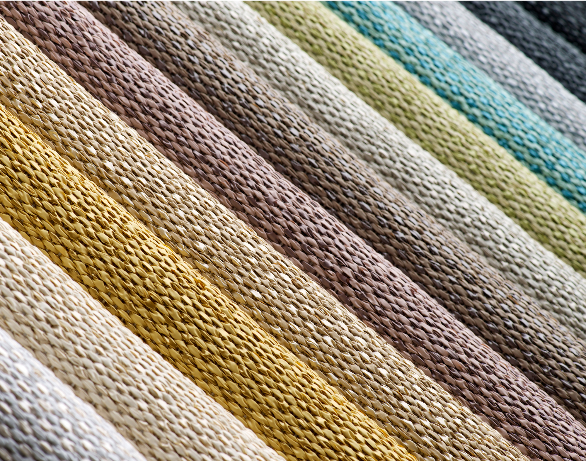Detailaufnahme des Svea Kunststoffteppichs von Pappelina, verschiedene Farben und Texturen für Bodenbeläge.