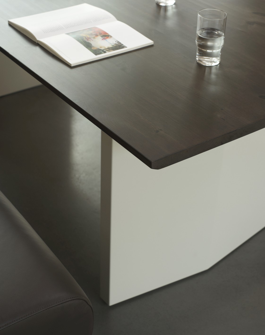 Detailaufnahme: Normann Copenhagen Panel Tisch, Esstisch mit dunkler Holzplatte und weißem Untergestell.