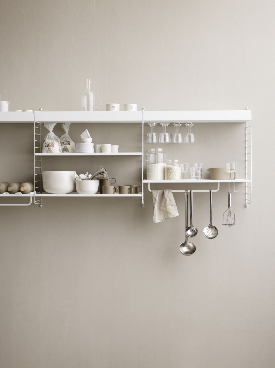 Detailaufnahme: Weiße String Furniture Regale mit Küchenutensilien und Lebensmitteln. Metallregal Stangen für flexible Wandgestaltung.