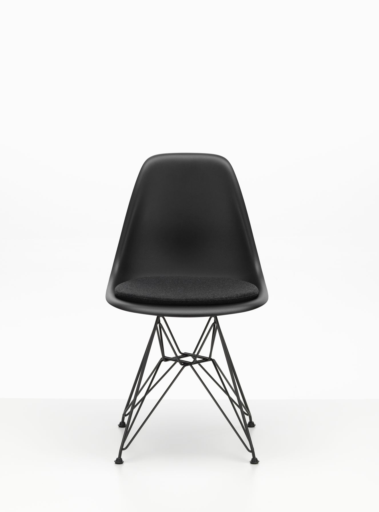 Schwarzer Vitra Eames Plastic Chair mit Soft Seats Sitzkissen in Pebble Grey für Indoor und Outdoor.