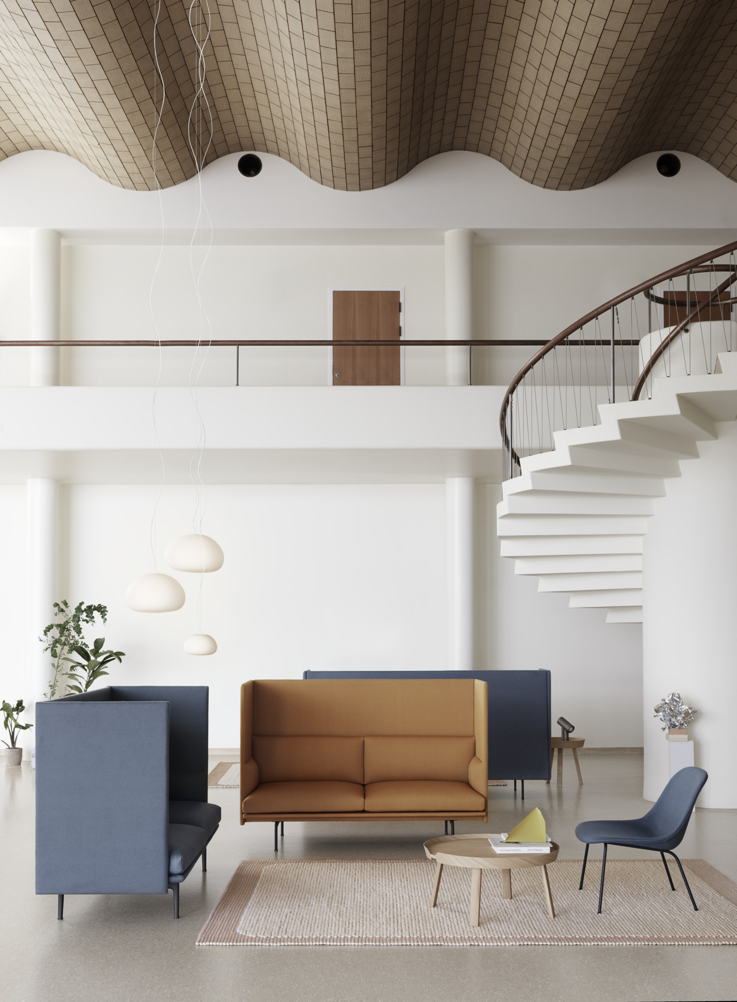 Helle, moderne Büroeinrichtung mit Muuto Beam Lamp Pendelleuchten, Sofas und Wendeltreppe.