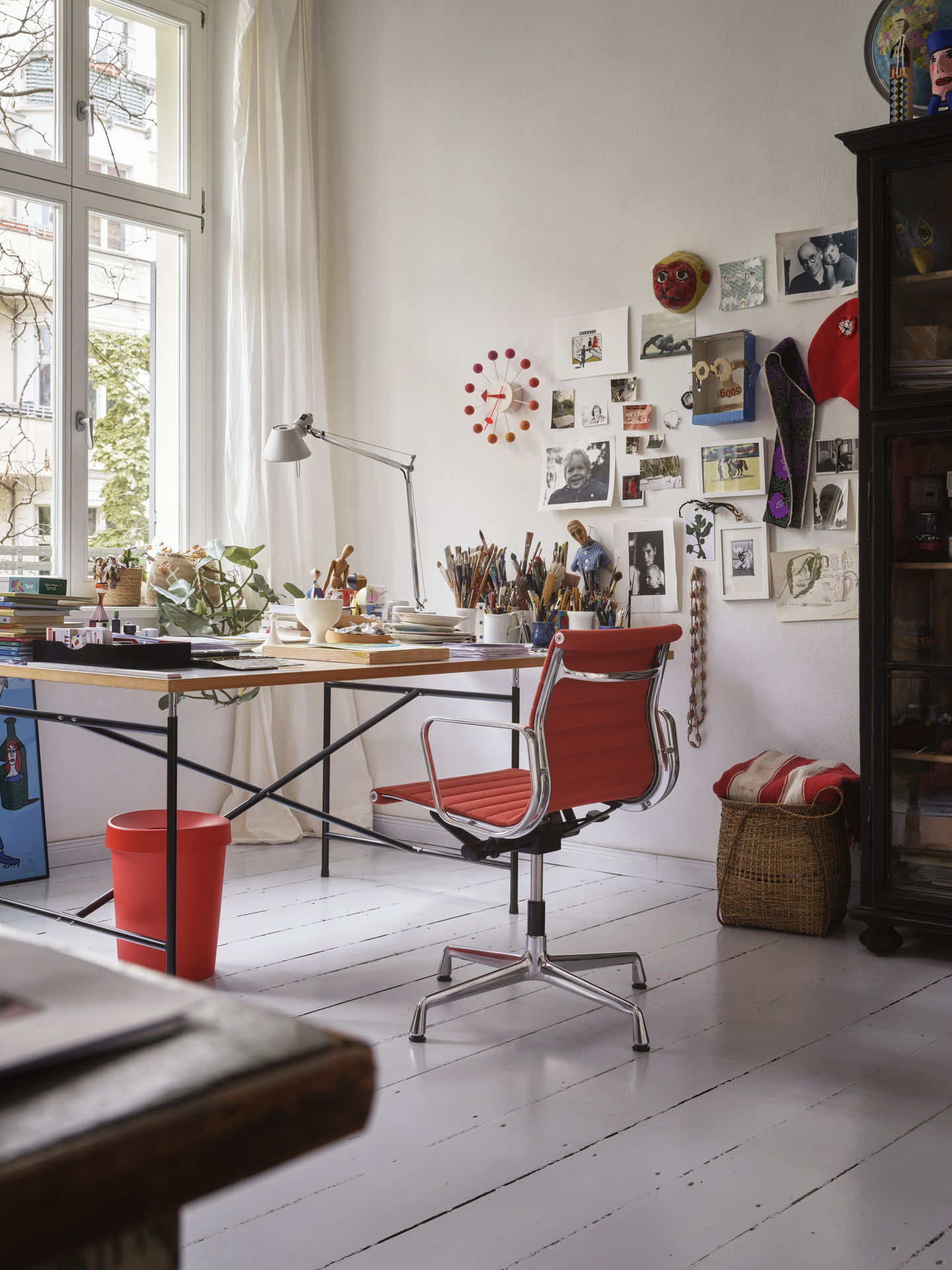 Roter Vitra EA 131 Aluminium Chair Bürostuhl am Schreibtisch in einem hellen Arbeitszimmer.
