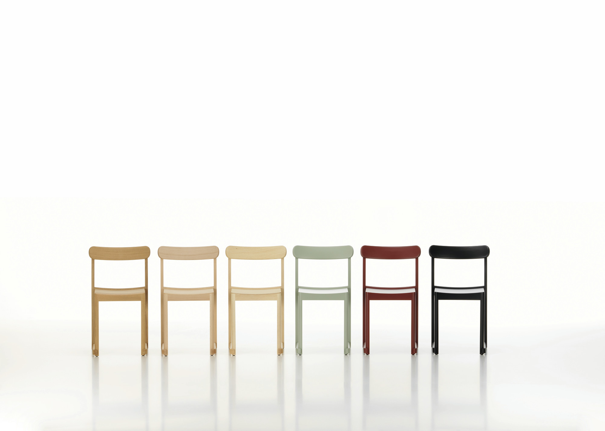 Reihe von Atelier Stühlen, Artek, verschiedene Farben, darunter ein dunkelrot lackierter Holzstuhl.