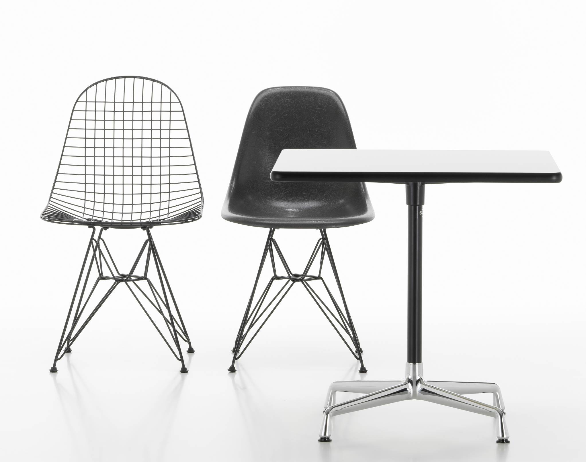 Vitra Eames Contract Table mit zwei Eames Stühlen in Schwarz und Draht-Optik.