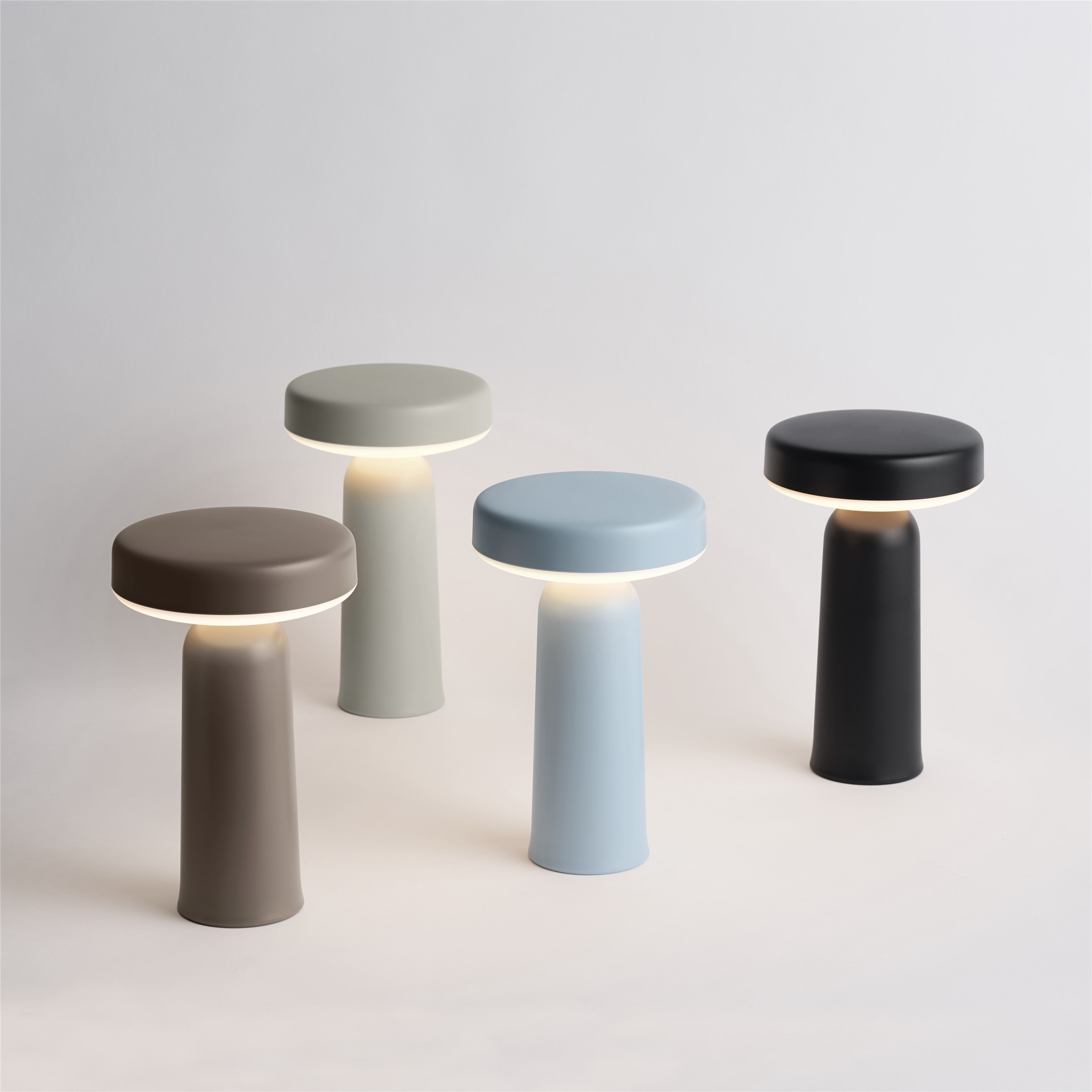 Mehrere Ease Portable Akku Tischleuchten von Muuto in verschiedenen Farben.
