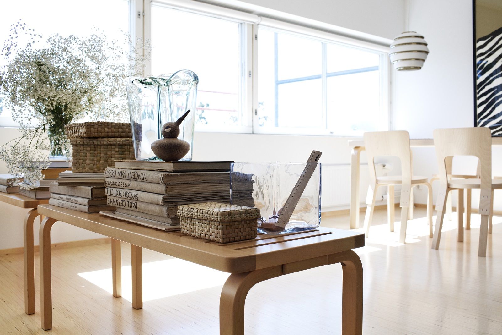 Artek Bench 153A aus Birkenholz im Interieur mit Dekorationen wie Bücher, Vasen und Körbe.