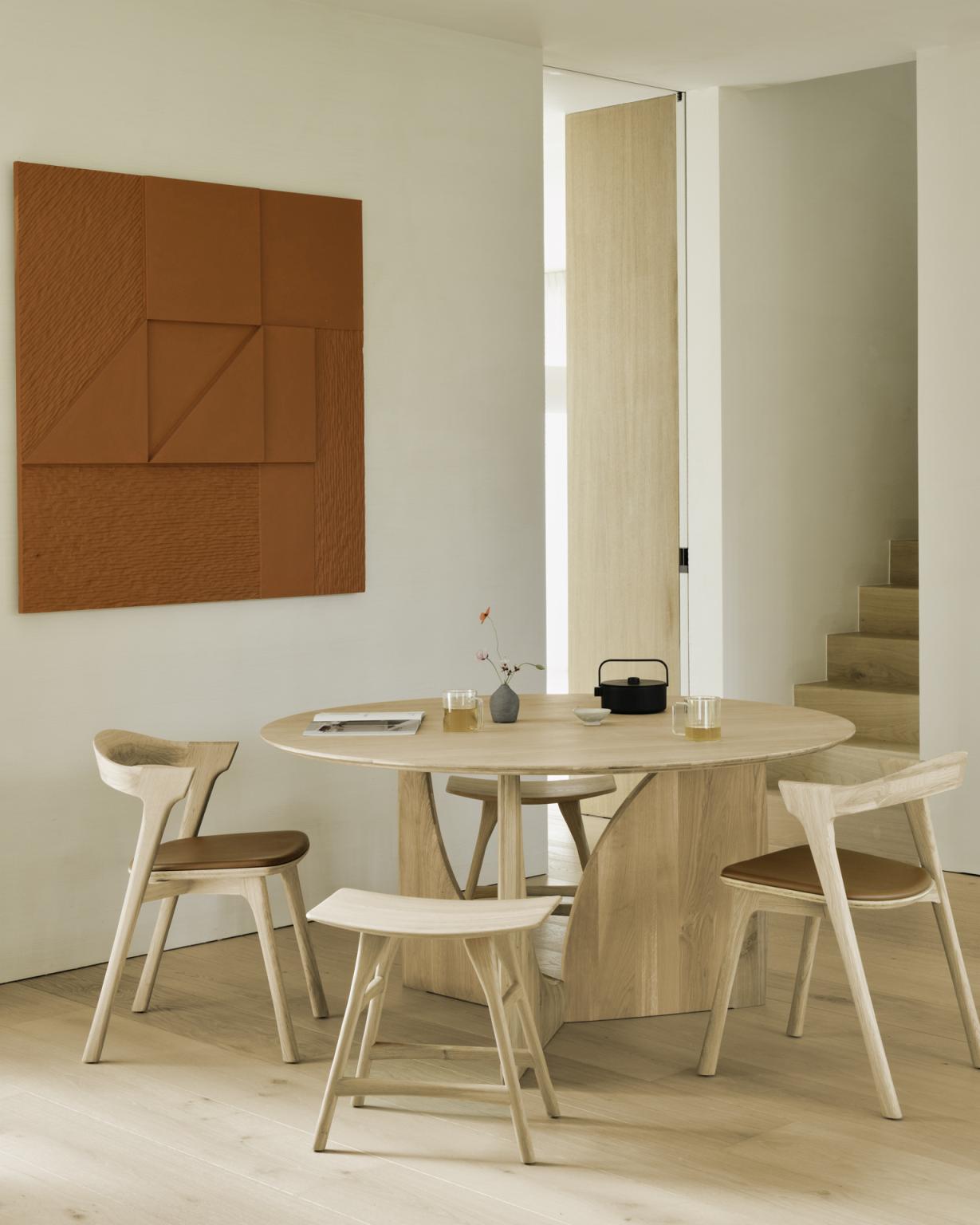 Ethnicraft Geometric Dining Table: Runder Holzesstisch mit Stühlen und Dekoration in modernem Interieur.