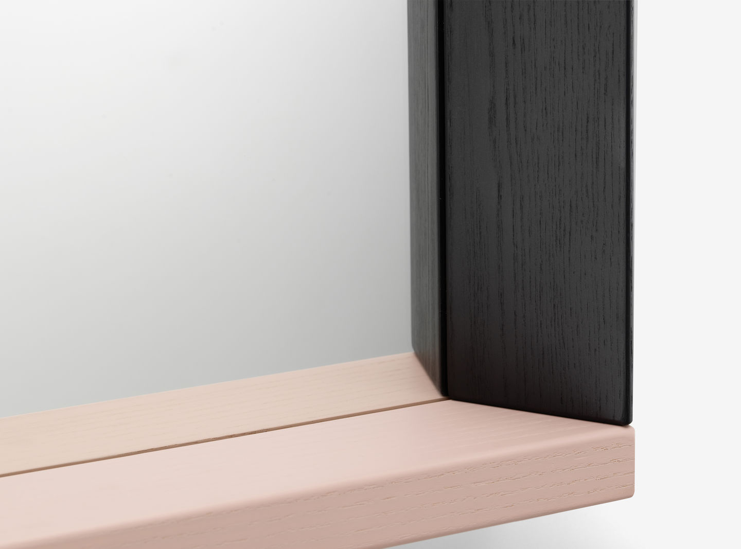 Detailaufnahme vom Vitra Colour Frame Spiegel mit schwarzem und rosa Rahmen.