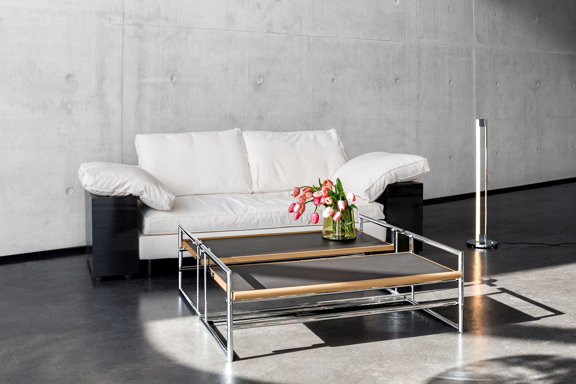 Helles Lota Sofa von Classicon mit schwarzen Armlehnen und Couchtisch im modernen Wohnzimmer.