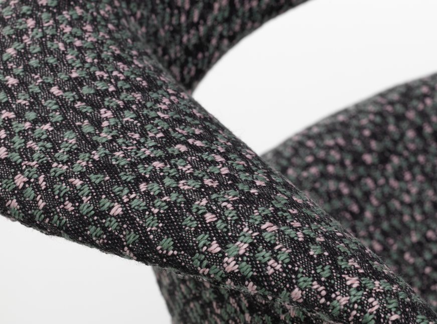 Detailaufnahme des Organic Conference Stuhls von Vitra mit Kvadrat Ria 03 Stoffmuster in Grün und Rosa.