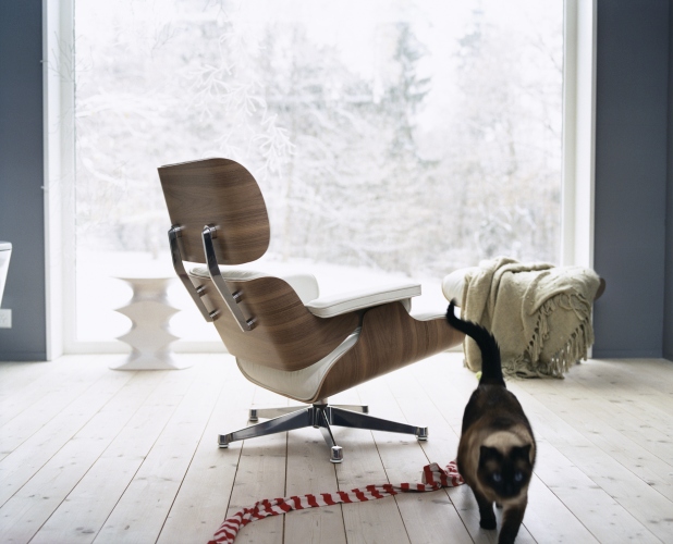 Eames Lounge Chair Sessel von Vitra mit weißem Leder und Walnussholz vor Fenster.