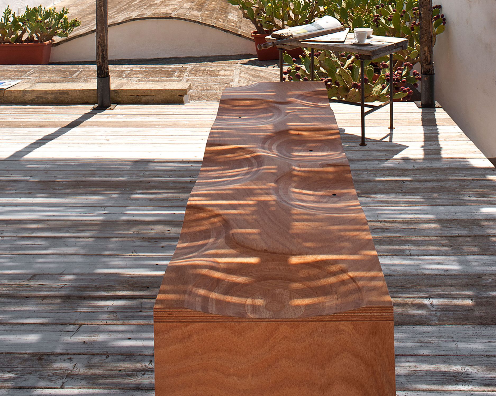 Holzbank Ripples von Casamania Horm für den Außenbereich auf einer Terrasse.