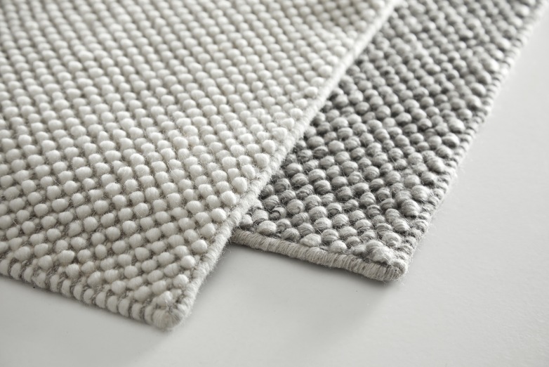 Detailaufnahme von zwei Tact Rug Teppichen, einer hellgrau, einer dunkelgrau, mit Noppenstruktur.