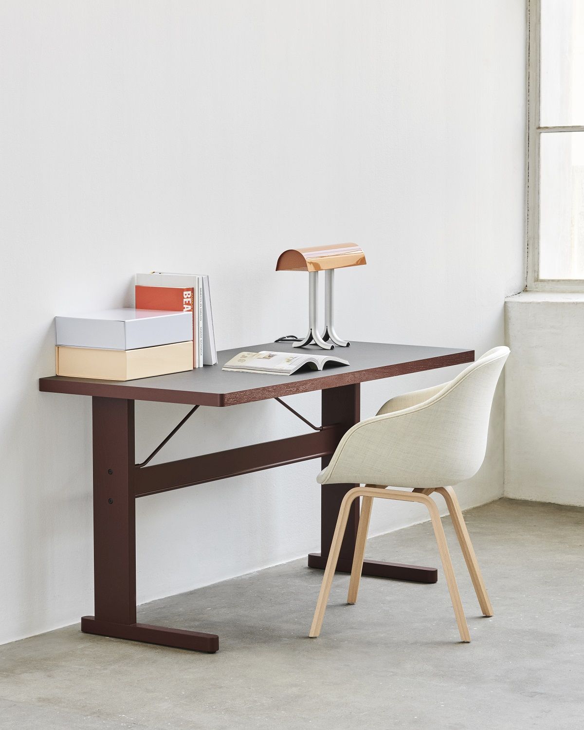 Beiger About a Chair AAC223 Stuhl von Hay an einem Schreibtisch mit Lampe und Büchern.