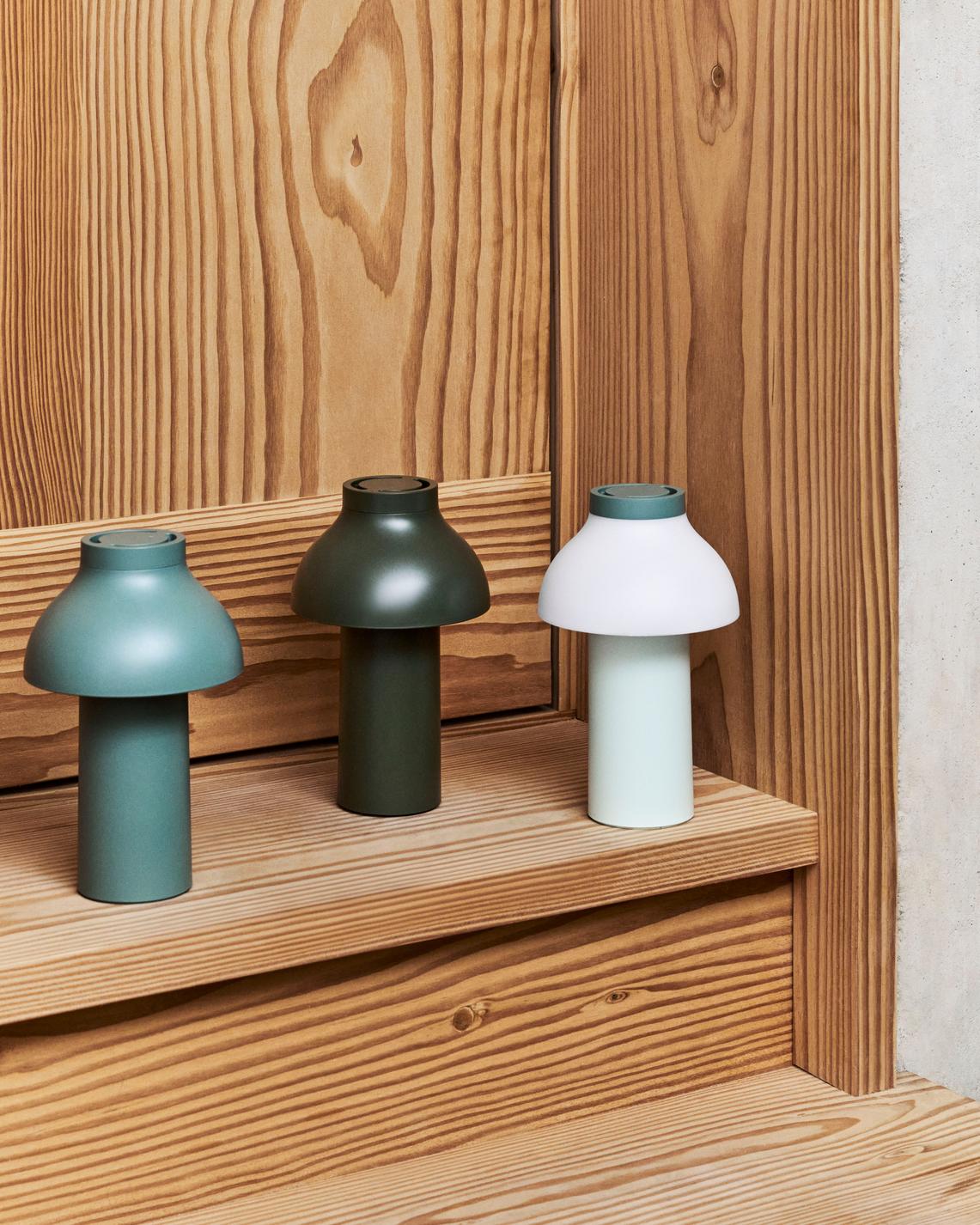 Drei Hay PC Portable Lampen in Grün- und Weißtönen auf einer Holztreppe, moderne Tischleuchten.