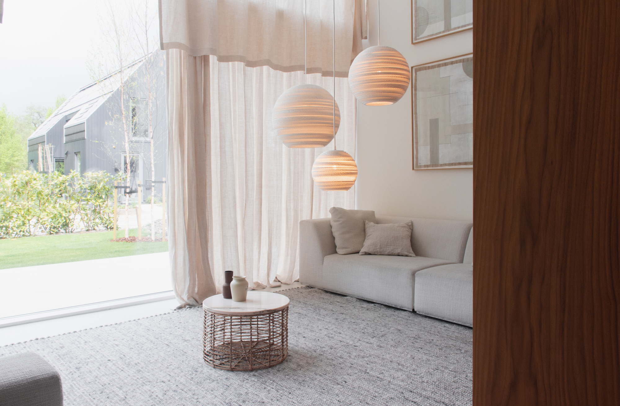 Scraplights Moon Hängeleuchten von Graypants in Weiß über Sofa im Wohnzimmer mit Tageslicht.
