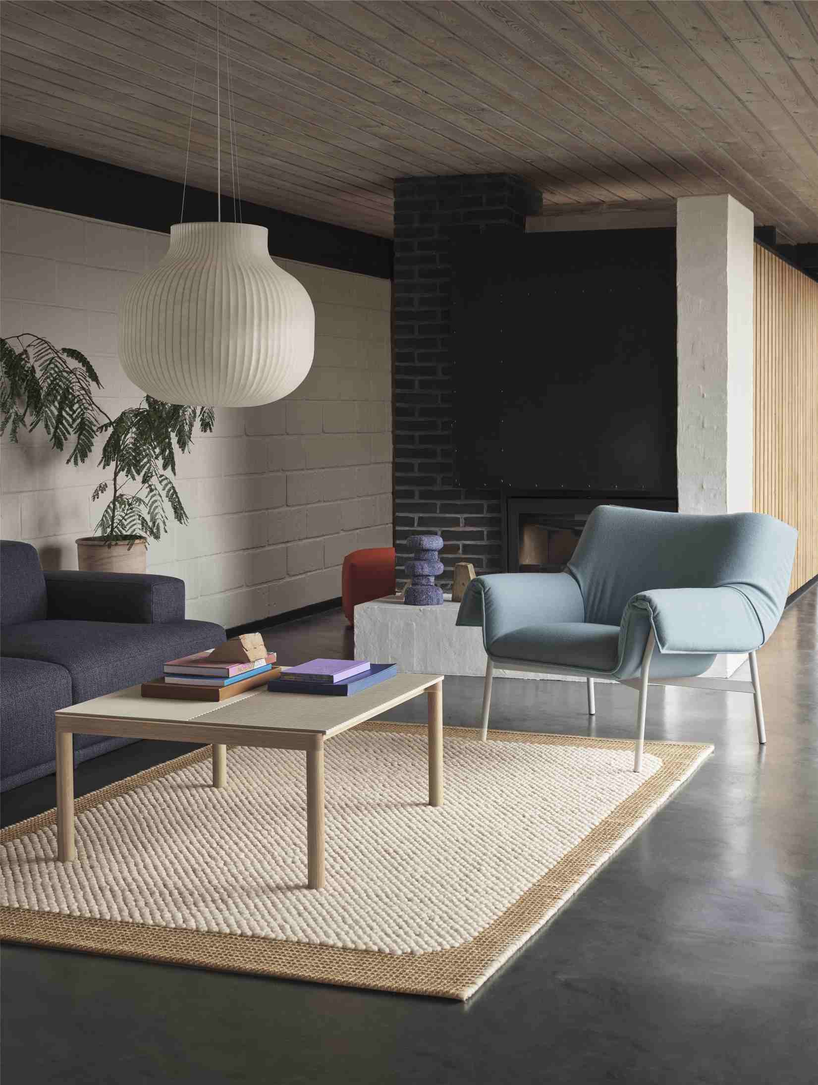 Wohnzimmer Interieur mit Muuto Couple Coffee Table Couchtisch, Sofa, Sessel, Teppich und Lampe für gemütliche Atmosphäre.