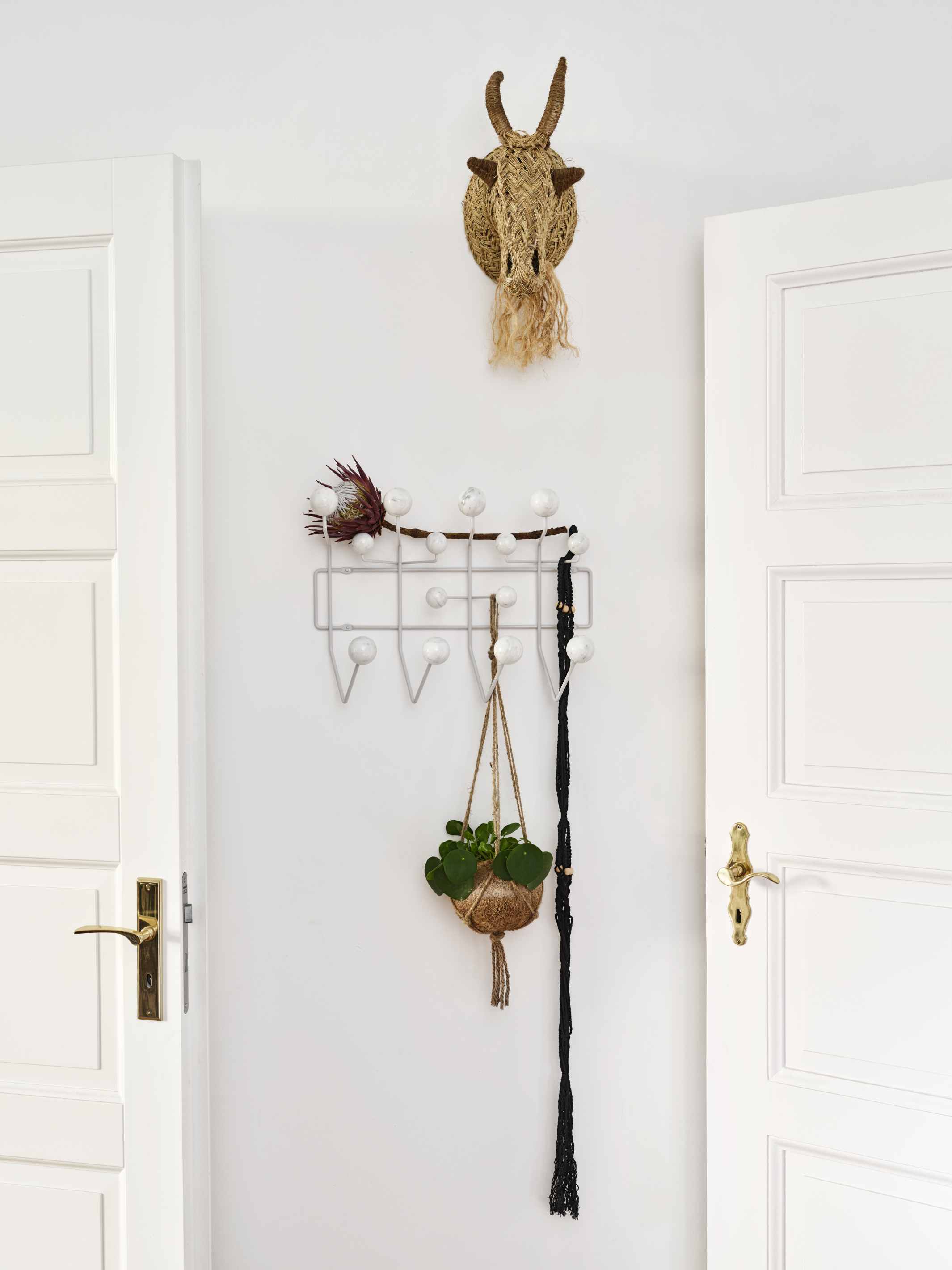 Eames Hang it all Garderobe Marmor Vitra LIMITED EDITION mit Dekoration an weißer Wand.