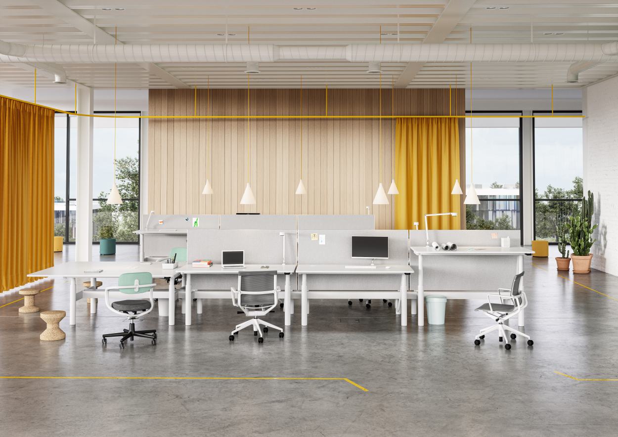 Helles Büro mit mehreren weißen Tyde Sitz- und Stehtischen von Vitra, Bürostühlen und gelben Akzenten.
