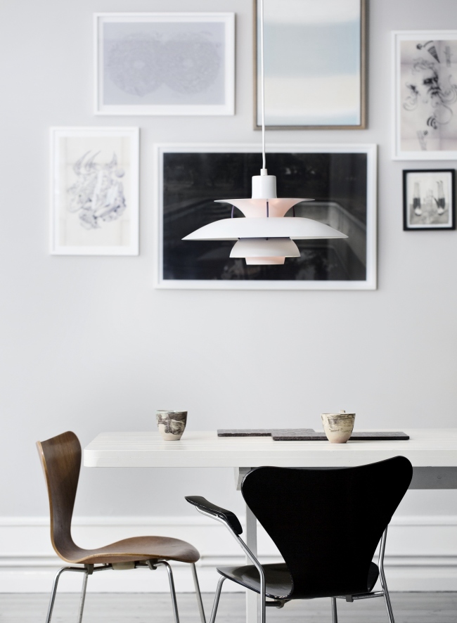 Moderne weiße PH 5 Pendelleuchte von Louis Poulsen über Esstisch mit Stühlen. Design Lampe.