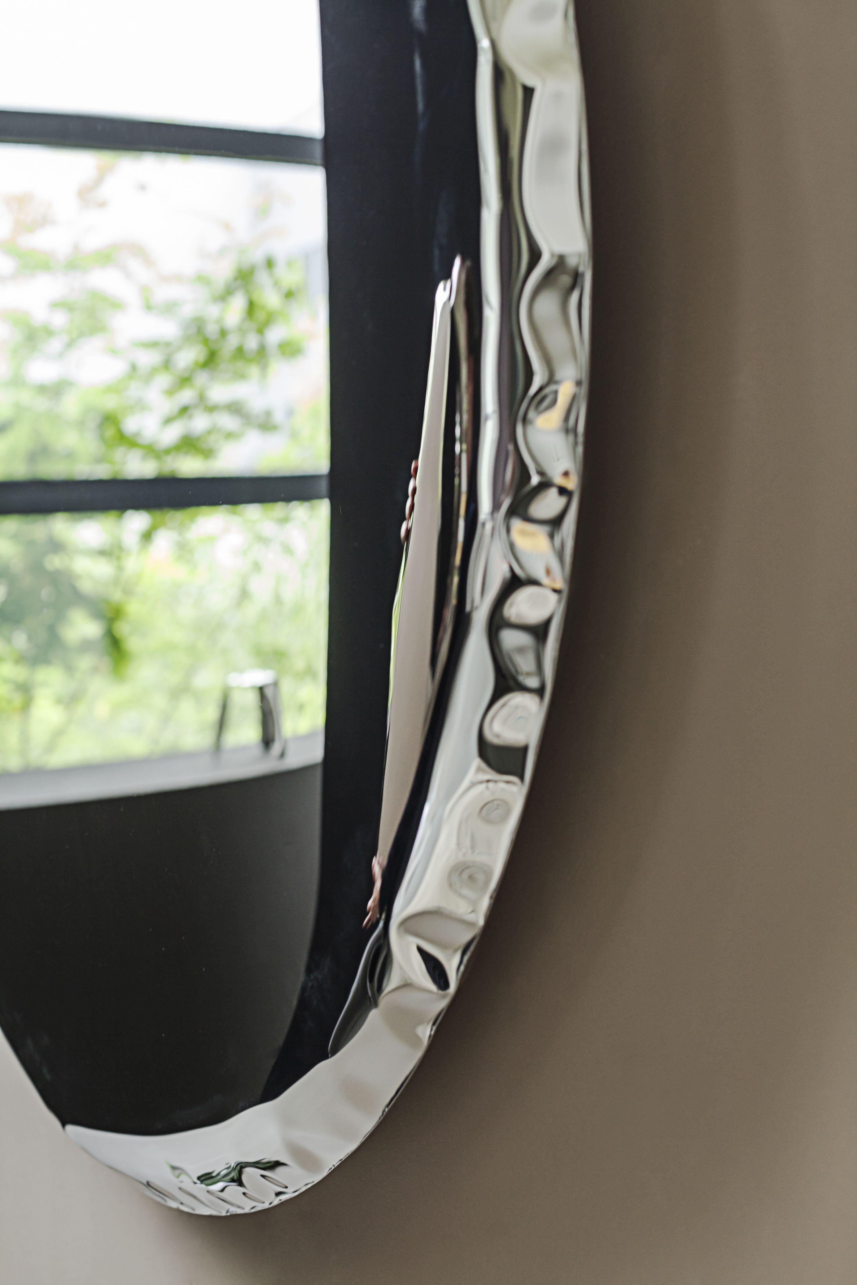 Nahaufnahme des Oko inox Spiegels von Zieta, ein runder Wandspiegel aus poliertem Edelstahl.