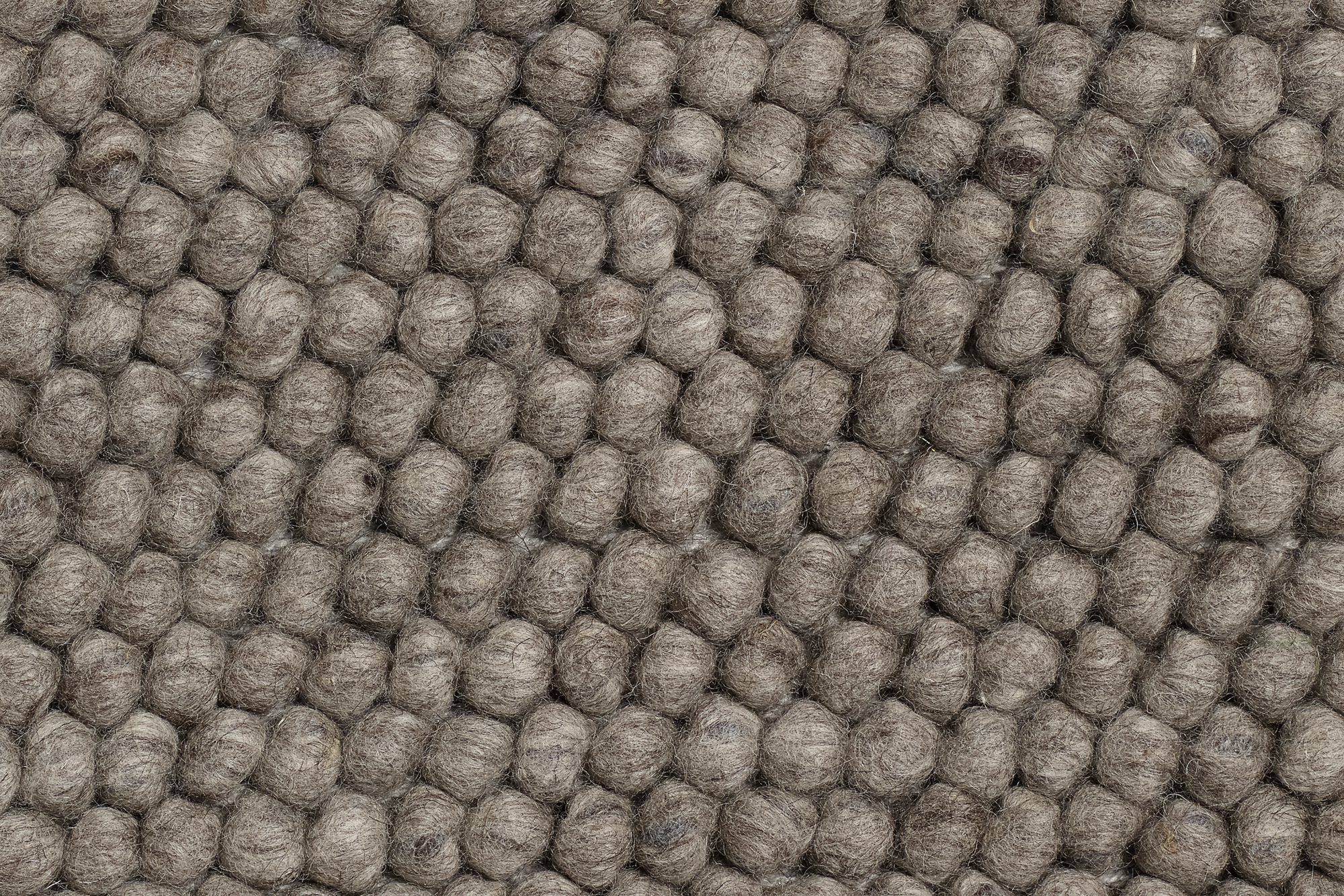 Detailaufnahme des grauen Hay Peas Teppichs (240x170cm) mit charakteristischer Kugelstruktur aus reiner Wolle.