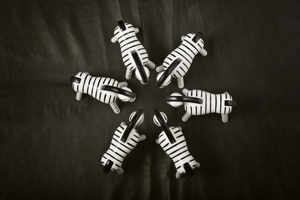 Fünf Kay Bojesen Zebra Holzfiguren, handgefertigt und Einzelstücke, auf dunklem Hintergrund angeordnet.