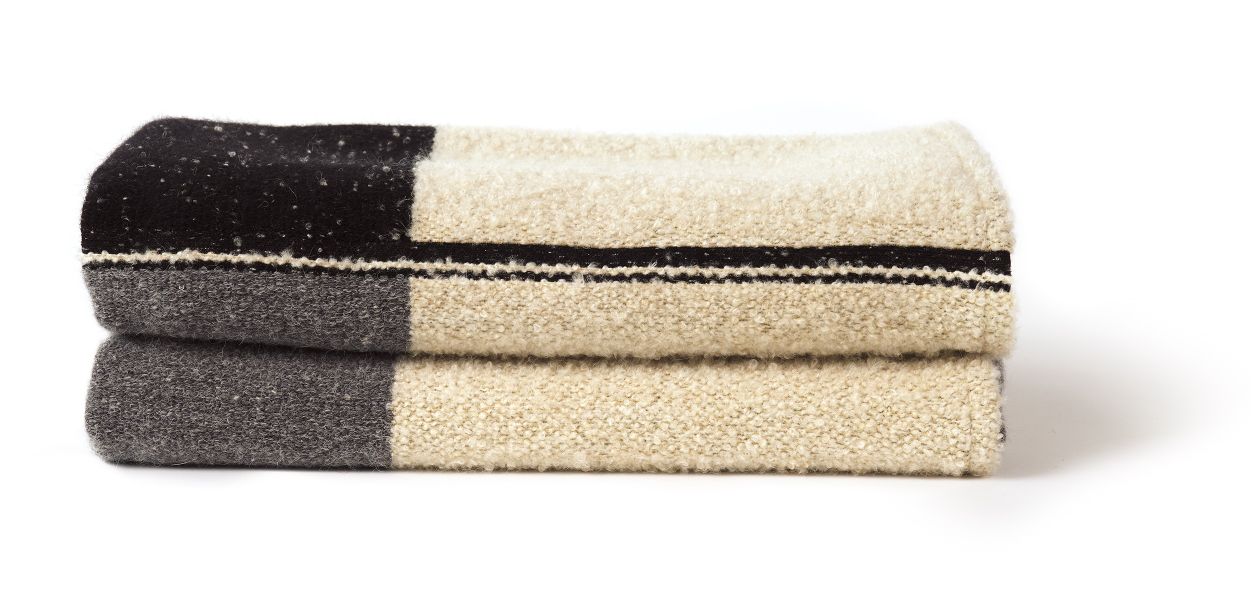 Zusammengelegter Urban Überwurf von Ethnicraft, eine weiche Tagesdecke mit Muster in Schwarz, Grau und Beige.