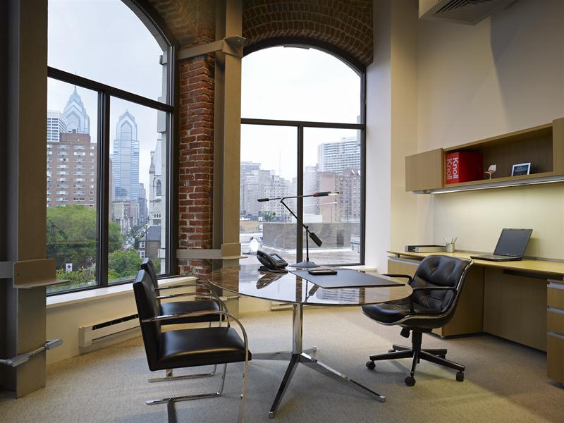 Knoll Pollock Bürostuhl mit schwarzen Lederbezug und Armlehnen in modernem Büro mit Blick auf die Stadt.