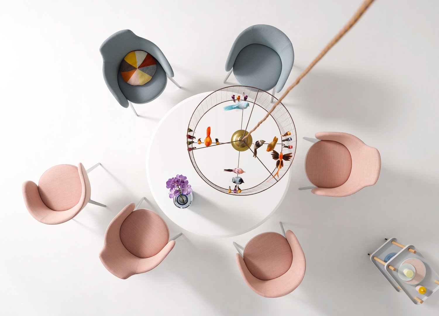 Vogelperspektive: Runde Esstischgruppe mit sechs modernen Stühlen in Rosa und Blau. Designermöbel für Esszimmer.