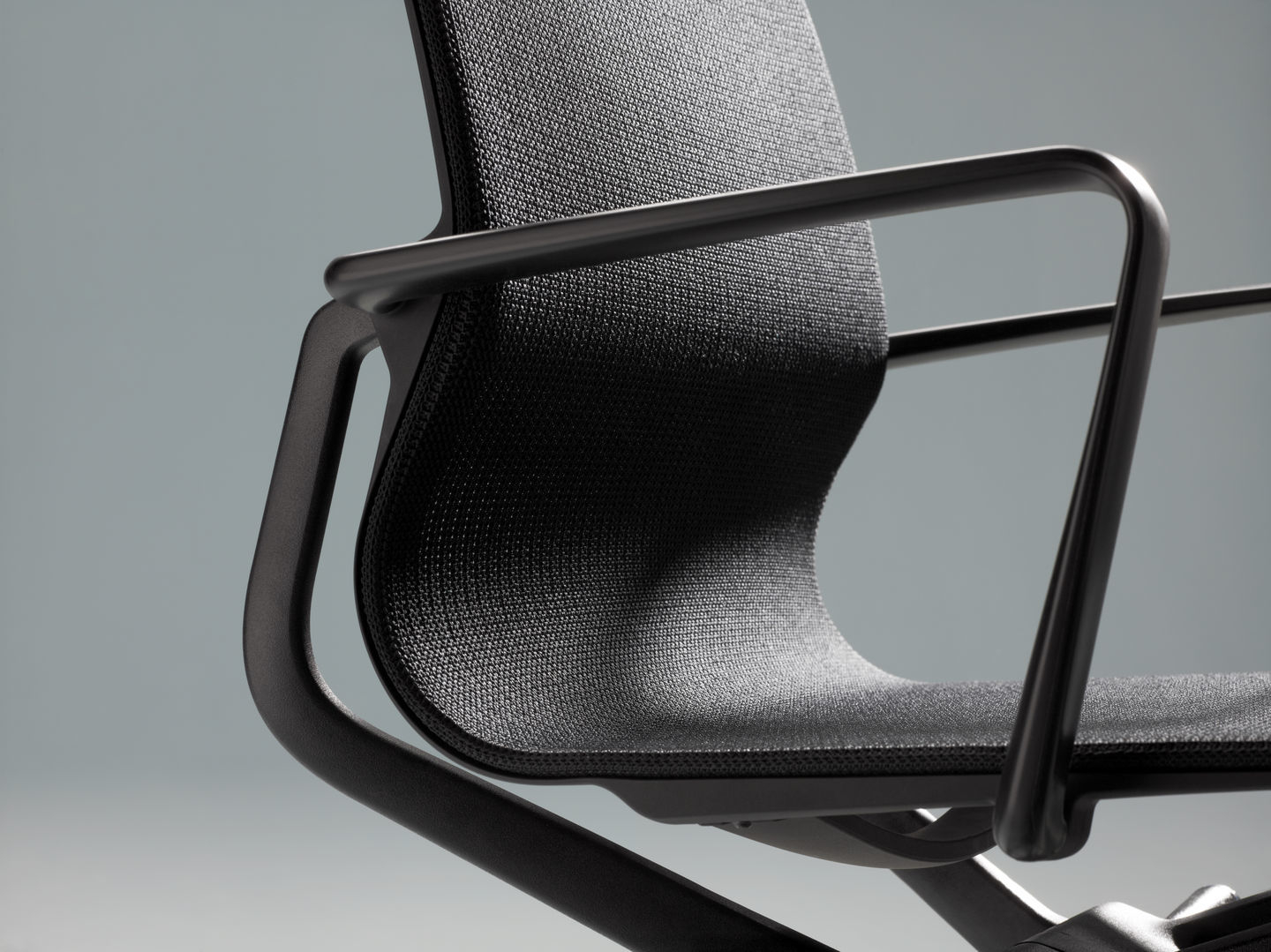 Detailaufnahme des schwarzen Physix Konferenzstuhls von Vitra mit Armlehnen und atmungsaktivem Stoffbezug.