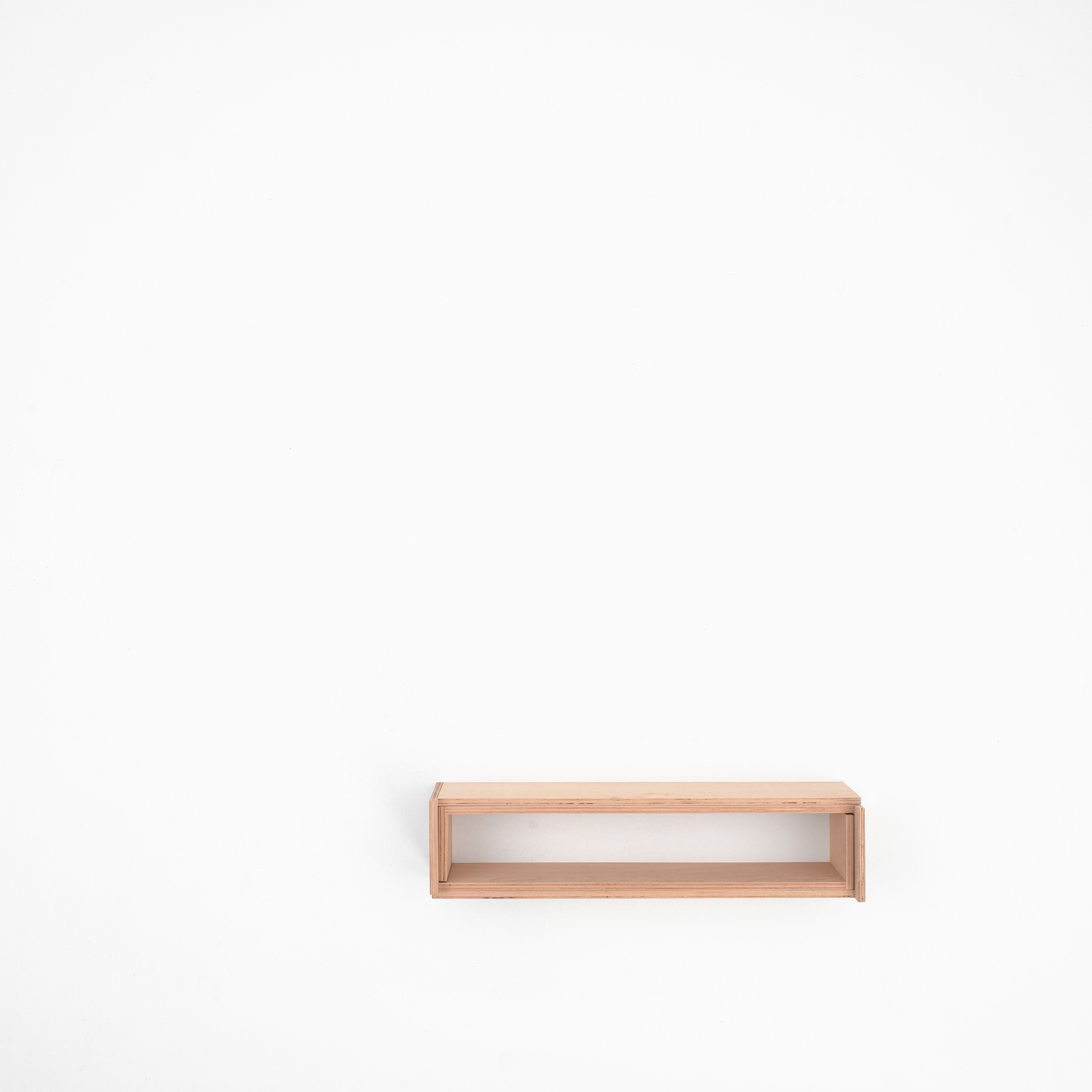 Tojo V Bett 90/180: Minimalistisches, helles Holz Bettgestell für moderne Schlafzimmer, freistehend vor weißer Wand.