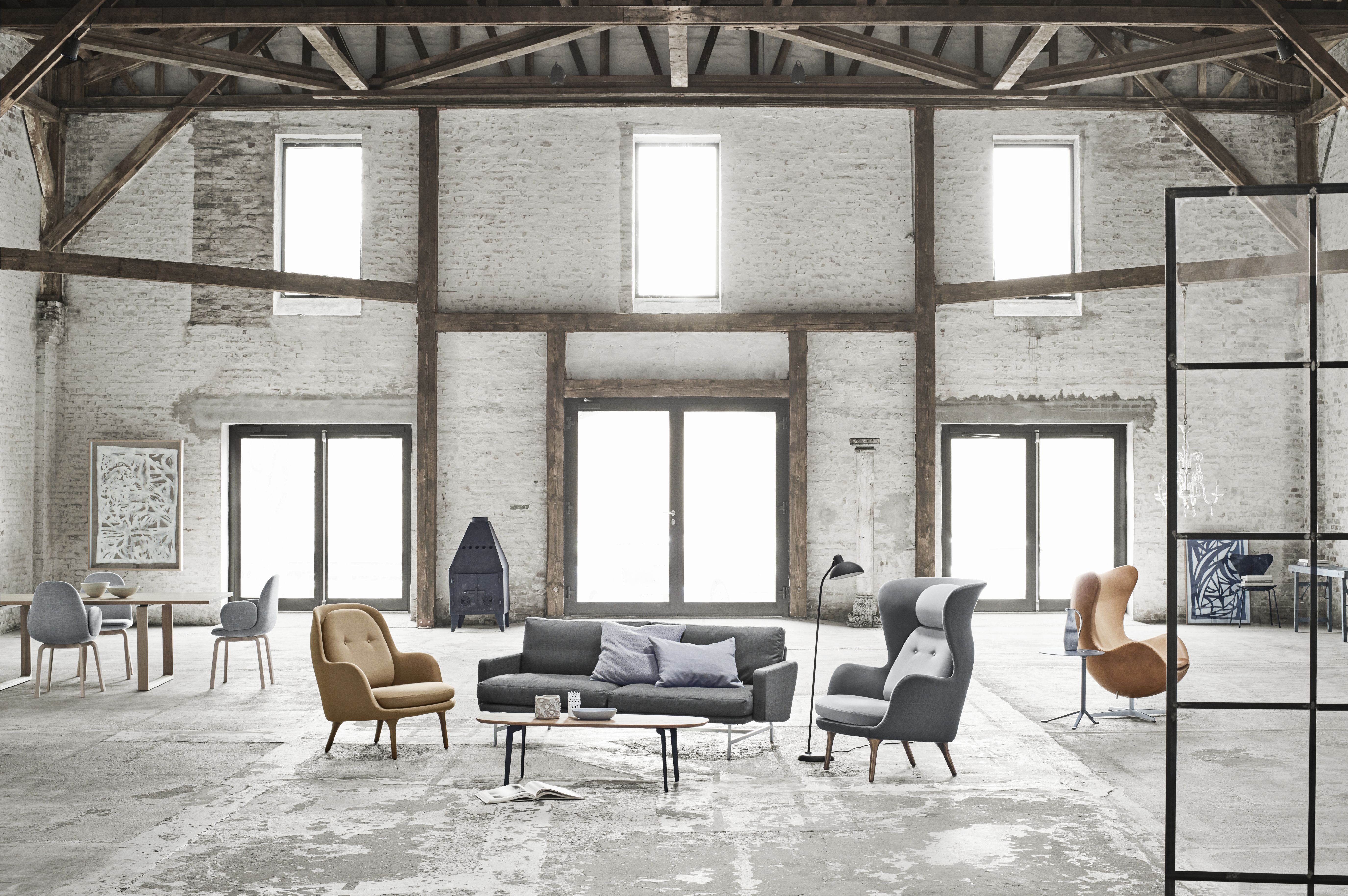 Ro Sessel von Fritz Hansen in Beige und Grau in Loft-Ambiente mit weiteren Möbeln.