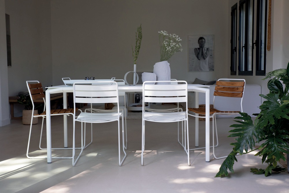 Essgruppe mit weißen Fermob Surprising Teak Stühlen und Tisch für den Garten oder die Terrasse.
