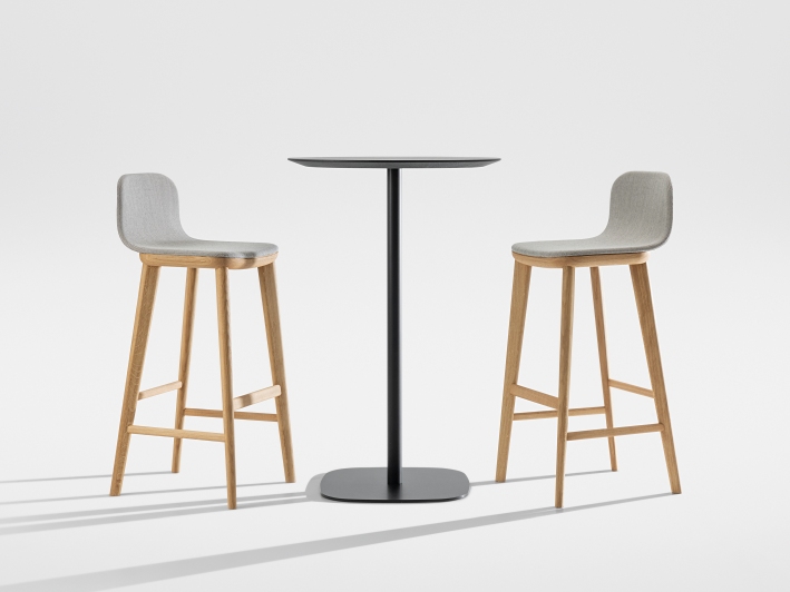 Aeon Barstool: Zwei moderne Barhocker mit grauem Bezug und Holzelementen an einem schwarzen Bartisch.